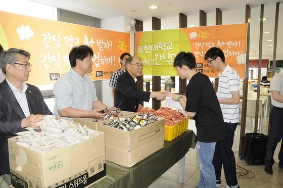 NSP통신-이권현 유한대학교 총장(가운데 학생과 악수)이 간식꾸러미를 나눠주고 있다. (유한대학교)