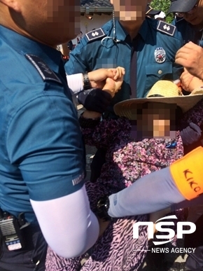 NSP통신-경찰 병력 3명이 서북청년단에 항의하는 소성리 마을 주민 (할머니)를 들어내는 모습 (사진 = 원불교성주성지비상대책위원회 제공)