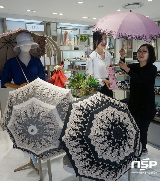 NSP통신-롯데백화점 대구점에서 고객이 햇빛을 가려주는 양산을 구경하고 있다. (롯데백화점 대구점)