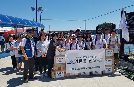 NSP통신-행정자치부 후원 독도사랑회 제4회 울릉도·독도 문화 탐방에 나선 청소년들이 독도로 가는 여객선을 승선하기 위해 울릉도 사동 항에서 풀무원과 칠갑농산이 후원한 위문품을 앞에 두고 기념사진을 찍고 있다. (독도사랑회)