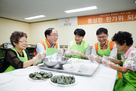 NSP통신-최광호 대표이사(왼쪽에서 두번째)를 비롯한 한화건설 봉사단과 복지관 어르신들이 이웃들에게 전달할 송편을 빚고 있다.