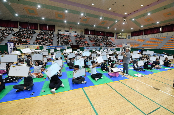 NSP통신-민주평화통일자문회의 오산시협의회가 주최한 중학생 역사통일 골든벨 행사에 참가한 학생들이 정답을 칠판에 적어 머리위로 들어올리고 있다. (오산시)