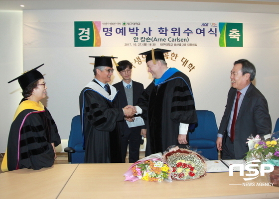 NSP통신-지난 27일 명예박사 학위 수여식에서 홍덕률 총장이 안 칼슨 전 유네스코 평생교육연구소장에게 명예박사 학위를 수여한 후 악수를 나누고 있다. (대구대학교)