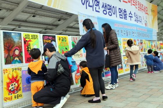 NSP통신-용인시청광장에서 용인시민들이 시청광장에 전시된 불조심 작품 공모 우수작 선정에 투표하고 있다. (용인소방서)