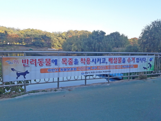 NSP통신-경기 성남시 탄천에 반려견 목줄 착용과 과태료 부과 내용을 알리는 현수막이 붙어 있다. (성남시)