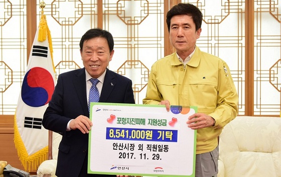 NSP통신-제종길 안산시장(왼쪽)이 시 공무원 안산시자원봉사센터 안산시건축사회가 모금한 포항지진피해 구호성금을 이강덕포항시장에게 전달하고 있다. (안산시)