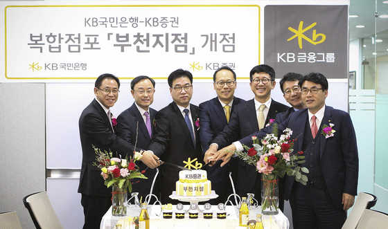 NSP통신-KB국민은행-KB증권 복합점포 개점행사에서 양재영 KB국민은행 부천지역영업그룹 대표(왼쪽 첫번째), 이재형 KB증권 WM총괄본부장 (오른쪽 세번째) 및 임직원들이 축하 케이크를 자르고 있다. (KB금융)