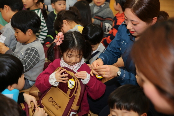 NSP통신-24일 경기남부경찰청 관계자가 유치원생의 가방에 노란뱃지를 걸어주고 있다. (경기남부경찰청)