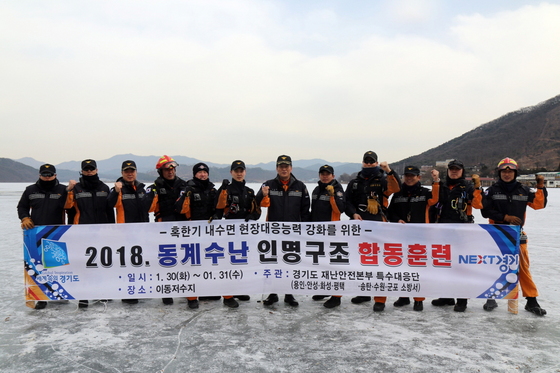 NSP통신-이동저수지에서 조창래 용인소방서장과 구조대원들이 2018 동계 수난구조훈련을 마치고 기념촬영을 하고 있다. (용인소방서)