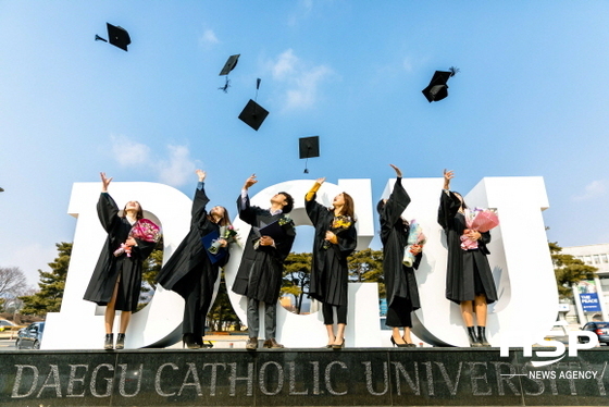 NSP통신-학위수여식이 열린 23일 대구가톨릭대 캠퍼스에서 졸업생들이 DCU조형물을 배경으로 기념 촬영을 하고 있다. (대구가톨릭대)