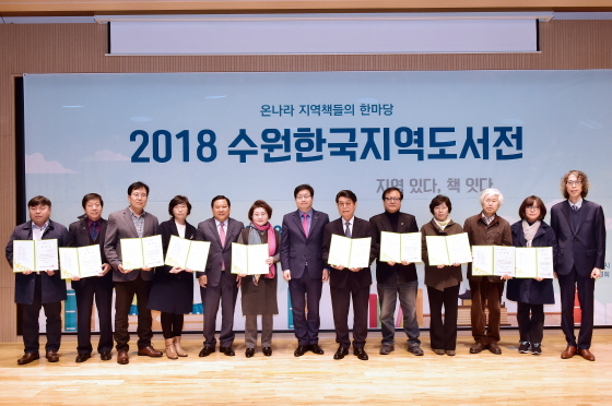 NSP통신-12일 염태영 수원시장(가운데)이 2018 수원한국지역도서전 조직위원회 위원들에게 위촉장 수여 후 함께 기념촬영을 하고 있다. (수원시)