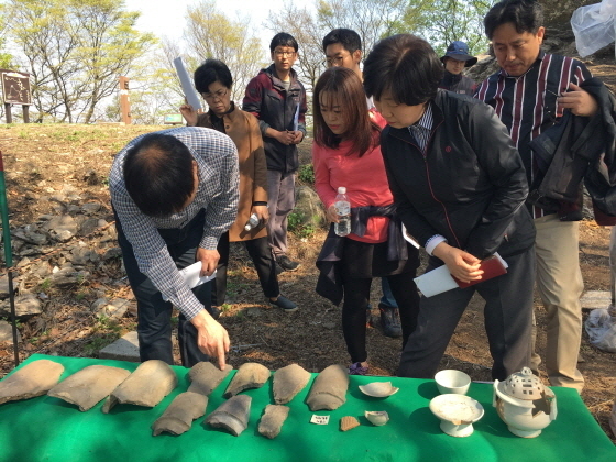 NSP통신-석성산봉수터 발굴현장에서 조사단과 자문위원들이 출토된 자기와 기와를 살펴보고 있다. (용인시)