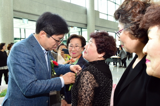 NSP통신-염태영 수원시장이 제46회 어버이날 기념행사에서 참석한 어르신들에게 카네이션을 달아주고 있다. (수원시)