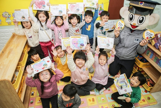 NSP통신-경찰관과 아이들이 우리아이 캠페인 뱃지와 그림을 들고 기념촬영을 하고 있다. (경기남부경찰청)