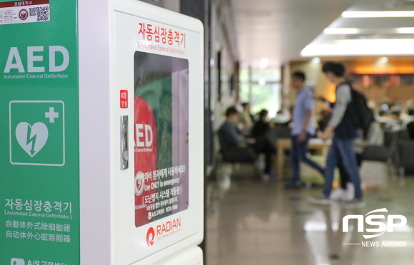 NSP통신-경일대 도서관 로비에 설치된 자동심장충격기 & 학생생활관 로비에서 심폐소생술 교육을 받고 있는 학생들. (경일대학교)