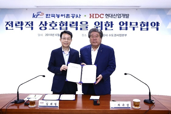 NSP통신-HDC현대산업개발 김대철 사장(왼쪽)과 한국농어촌공사 최규성 사장(오른쪽)이 업무협약을 체결하고 기념촬영을 하고 있다. (HDC현대산업개발)