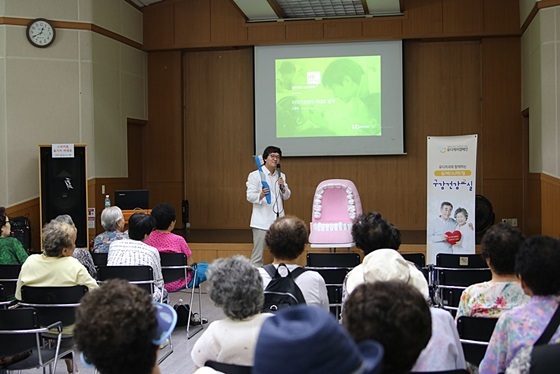 NSP통신-고광욱 유디치과 대표원장이 어르신에게 구강건강교육을 진행하고 있는 모습 (유디치과)