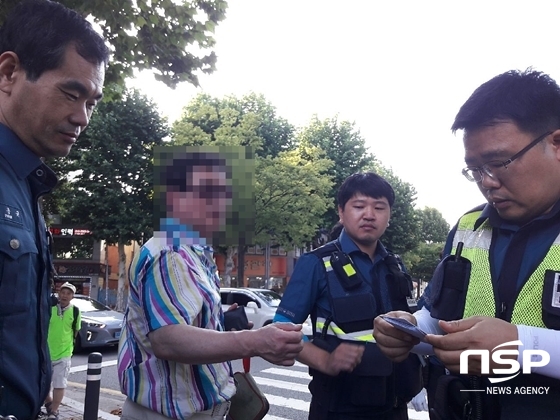 NSP통신-동서시장 인근 노상에서 피해자를 폭행한 A씨가 현장에 출동한 경찰관에게 조사를 받고 있다. (독자 제공)