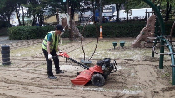 NSP통신-오산시 관계자가 도시공원 놀이터 모래를 소독하고 있다. (오산시)