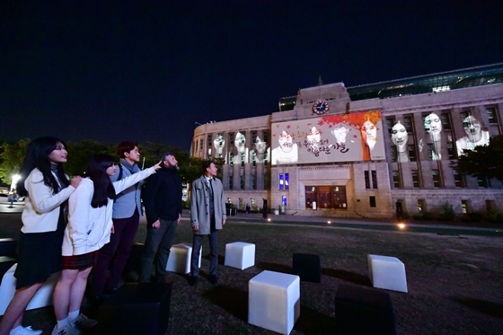 NSP통신-벽면에 상영되고 있는 2018 서울거리예술축제의 공식 초청작을 관람하고 있 (한성자동차)