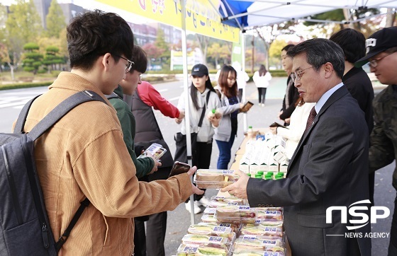 NSP통신-곽병선 군산대 총장(오른쪽)이 구 정문 앞 광장에서 조기 등교하는 학생들에게 간편식을 나눠주고 있다.