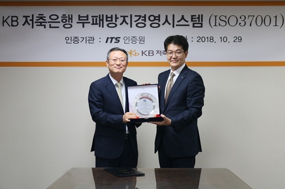 NSP통신-KB저축은행 신홍섭 대표이사(가운데 좌측)와 ITS인증원 박준영 원장(가운데 우측)이 인증서를 함께 들고 있는 모습. (KB저축은행)
