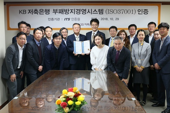 NSP통신-KB저축은행 신홍섭 대표이사(가운데 좌측)와 ITS인증원 박준영 원장(가운데 우측)이 인증서를 함께 들고 있는 모습. (KB저축은행)
