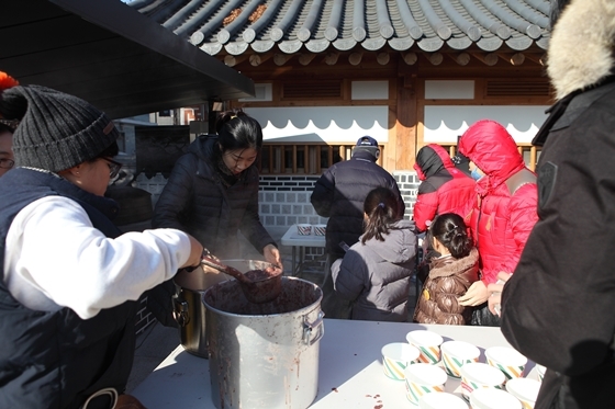 NSP통신-수원문화재단 동지 체첨행사 참가자들이 팥죽을 배식하고 있다. (수원문화재단)