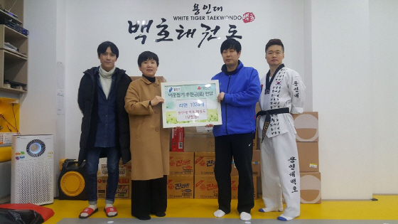 -15일 상현동 용인대백호태권도에서 어려운 이웃을 위해 써 달라며 라면 1024개를 기탁한 가운데 기념촬영을 하고 있다. (용인시)