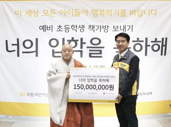 NSP통신-이동철 KB국민카드 사장(오른쪽)이 원행 스님 재단법인 아름다운 동행의 이사장에게 책가방 선물 세트를 전달하고 기념촬영을 하고있다. (국민카드)