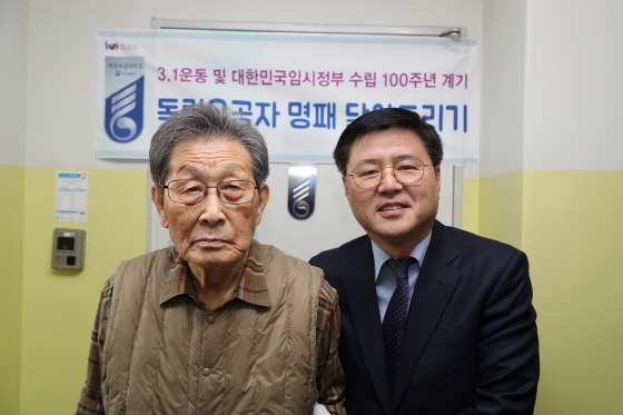 NSP통신-한대희 군포시장이 항일독립유공자 김유길 옹(왼쪽)의 대문에 독립유공자 명패를 달고 기념촬영을 했다.
