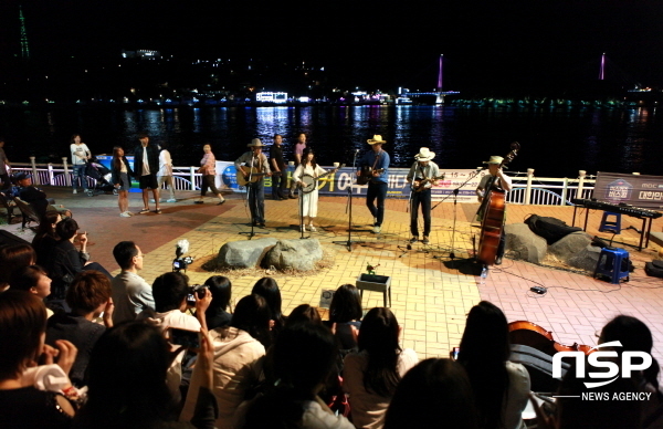 NSP통신-낭만버스킹 공연팀이 여수밤바다를 배경으로 연주를 하고 있다. (여수시)