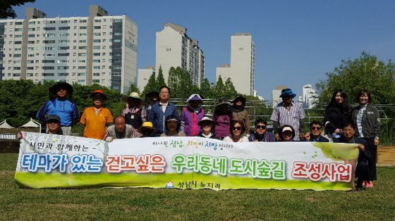 NSP통신-성남시 테마가 있는 걷고 싶은 우리동네 도시 숲(꽃)길 조성 사업 가운데 녹지과 관계자들이 야탑2동 주민들과 기념촬영을 하고 있다. (성남시)