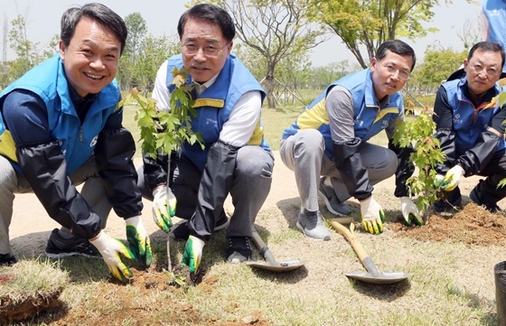 NSP통신-24일 서울식물원 단풍나무원 조성활동 행사에 참여한 진옥동 신한은행장(왼쪽)과 조용병 신한지주 회장(오른쪽)이 그룹사 CEO과 단풍나무를 심고있다. (신한지주)