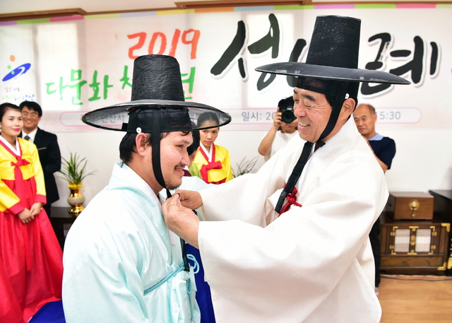 NSP통신-8일 개최된 전통성년례에서 윤화섭 안산시장(오른쪽)이 직접 다문화청소년에게 관을 씌워주고 있다. (안산시)