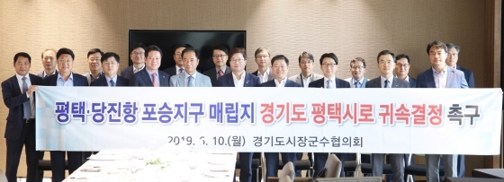 NSP통신-10일 수원컨벤션센터에서 경기도시장군수협의회가 평택·당진항 포승지구 공유수면 매립지에 대해 헌법재판소와 대법원이 조속히 평택시로 귀속 결정할 것을 촉구하는 공동결의문을 채택하고 기념촬영을 하고 있다. (평택시)