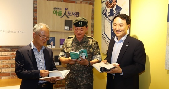 NSP통신-이날 개관식에 참여한 권혁신 1군단 부군단장(가운데), 문동권 신한카드 경영기획그룹장(오른쪽)이 아름인 도서관 시설을 둘러보고있다. (신한카드)