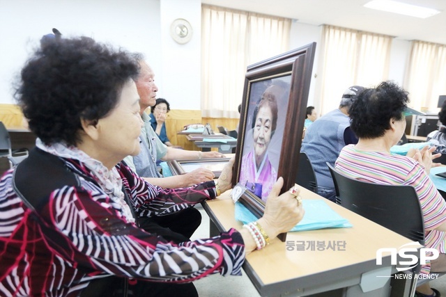 NSP통신-어르신들이 둥글개봉사단으로부터 받은 장수사진을 바라보고 있다. (김종식 기자)