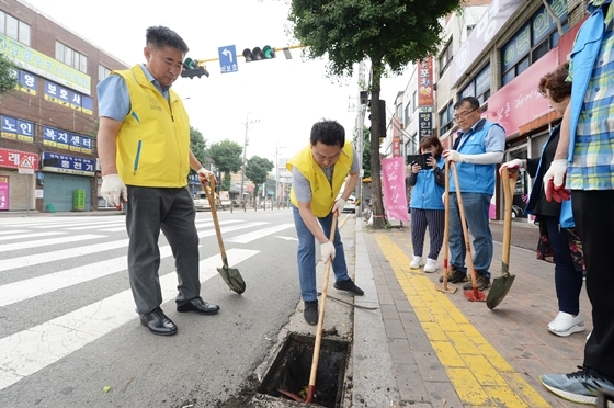 NSP통신-오산시의회 관계자들이 22일 오산시 지역자율방재단과 도로변 배수로 정비활동을 전개하고 있다. (오산시의회)