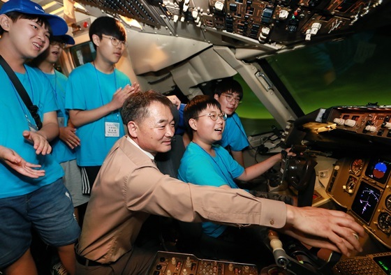 NSP통신-참가자들이 아시아나항공 운항승무원들이 실제로 비행훈련을 실시하는 항공기 시뮬레이터를 체험하고 있다. (아시아나항공)
