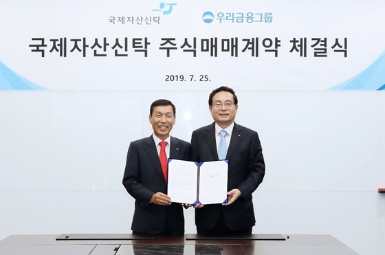 NSP통신-손태승(오른쪽) 우리금융 회장과 유재은 국제자산신탁 회장(왼쪽)이 계약 체결 후 기념촬영을 하고 있다. (우리금융지주)