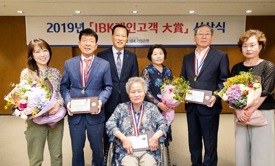 NSP통신-김도진 기업은행장(왼쪽 세 번째), 안현자 고객(가운데), 김수영 고객(오른쪽 두 번째), 김영식 고객(왼쪽 두 번째)과 가족들이 IBK개인고객 대상 시상식을 마치고 기념촬영을 하고있다. (기업은행)