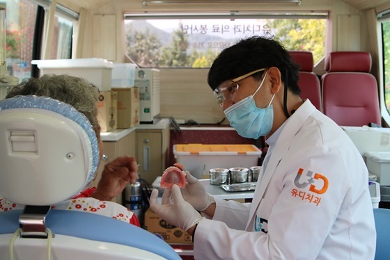 NSP통신-진세식 유디강남치과의원 대표원장이 어르신의 치아를 검진 한 후 틀니관리방법을 설명하고 있다 (유디치과)