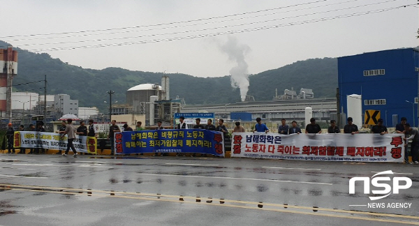 NSP통신-남해화학의 최저가 입찰에 항의하는 근로자들이 비가 내리고 있어도 현수막을 펼치고 시위하고 있다. (협력업체근로자)
