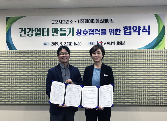 NSP통신-2일 군포시와 케이티에스테이트가 건강일터 만들기 업무협약을 체결한 가운데 김태진 kt estate 단장(왼쪽)과 김미경 군포시 보건소장이 기념촬영을 하고 있다. (군포시)