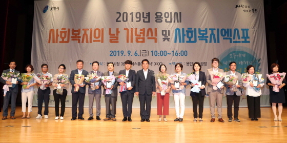 NSP통신-6일 용인시청 에이스홀에서 열린 사회복지의 날 기념행사 가운데 백군기 용인시장(오른쪽 여덟번째)이 사회복지 증진과 나눔문화 확산에 기여한 공로로 시장상, 국회의원상 등을 받은 수상자들과 기념촬영을 하고 있다. (용인시)