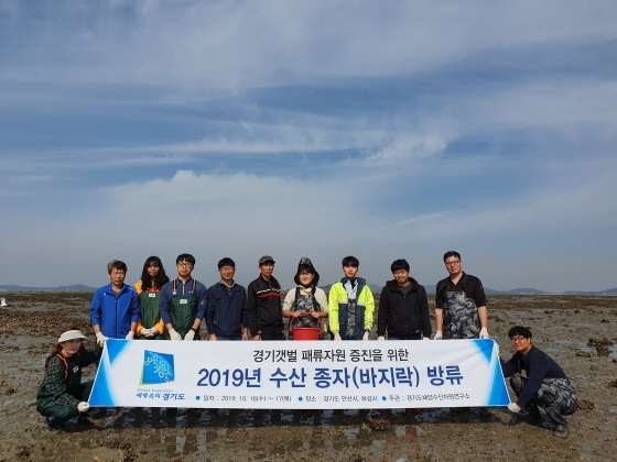 NSP통신-경기도 해양수산자원연구소가 갯벌 연안에 바지락 치패를 방류한 가운데 관계자들이 기념촬영을 하고 있다. (경기도)