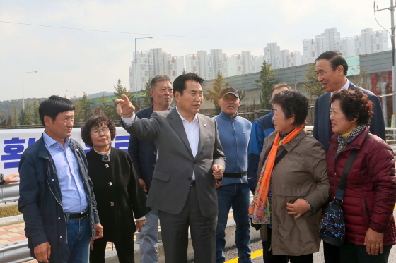 NSP통신-31일 백군기 용인시장이 주민들과 함께 대동교 확장 개설 현장을 돌아보고 있다. (용인시)