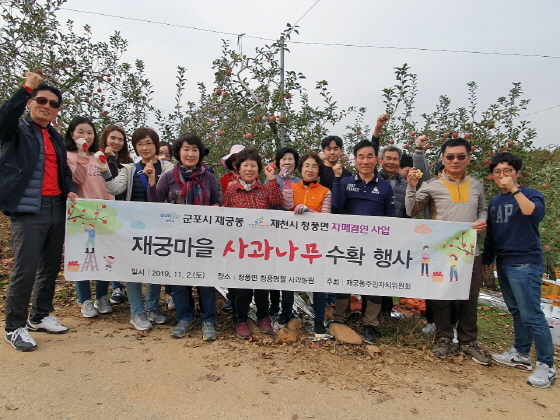 NSP통신-군포시 재궁동 주민들이 충청북도 제천시 청풍면을 방문해 각자의 이름표가 달린 사과나무에서 열매를 수확한 후 기념촬영을 하고 있다. (군포시)