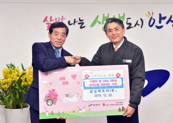 NSP통신-23일 안산시가 삼성에프씨로부터 사랑의 쌀 10kg 100포와 과자선물세트 200개를 기탁받은 가운데 윤화섭 안산시장(왼쪽)과 삼성에프씨 관계자가 기념촬영을 하고 있다. (안산시)